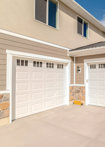 Modern white garage doors with small windows.