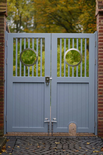 Bespoke wooden garden gates with circular details and hedgehog hole.