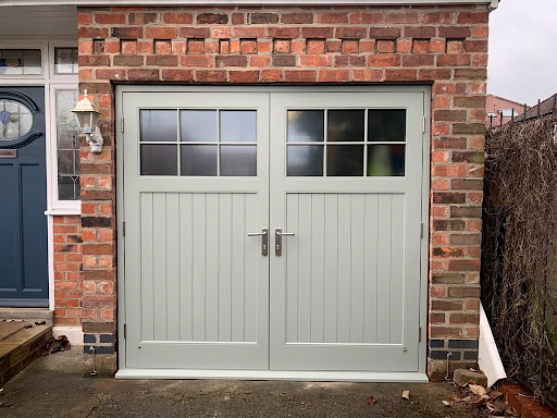 Light grey wooden garage door with window panes.